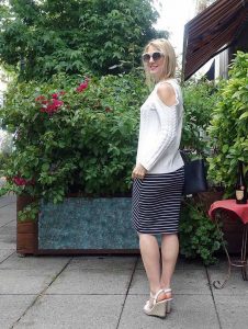 Cold-shoulder sweater and striped skirt
