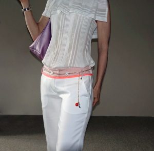 Close up of chain belt on narrow-legged white pants